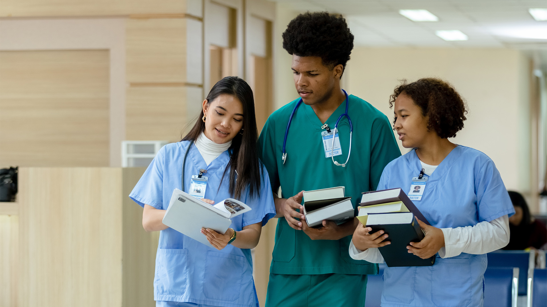 A nurse and two students discuss in a hallway